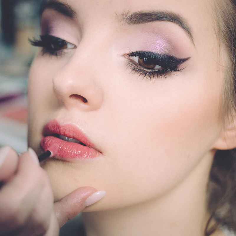 Makeup artist applying lipstick for an occasion look