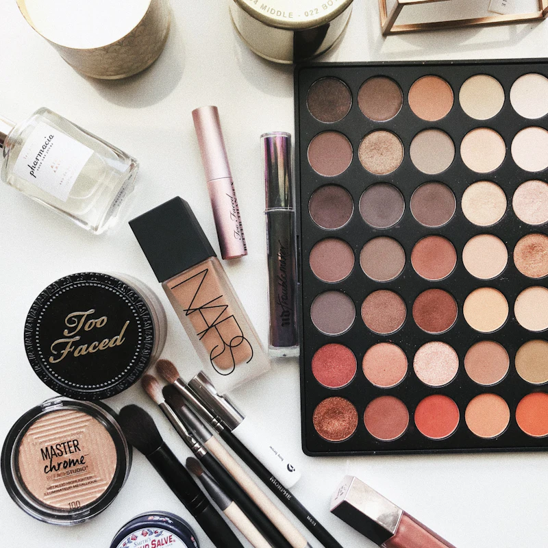 Neutral eyeshadow palette and makeup products flatlay
